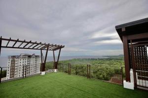 a balcony with green grass and a building at DHub Space Panglao in Dauis