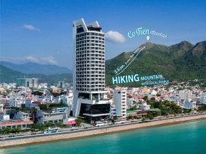 a tall building with a sign on it next to the water at Boton Blue Hotel & Spa in Nha Trang
