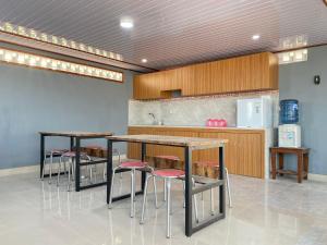 eine Küche mit zwei Tischen und Hockern in einem Zimmer in der Unterkunft d'WF Hotel in Yogyakarta