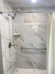 una ducha con puerta de cristal en un baño en King Bed Suite, Fireside Hot Tub, Gameroom, en Auburndale