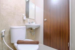 a bathroom with a toilet and a sink at Best Homey 2BR at Transpark Cibubur Apartment By Travelio in Depok +10 photos