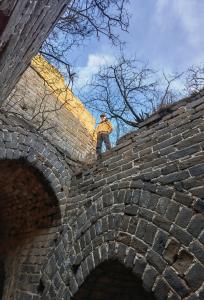 a man standing on top of a brick wall at Beijing Wuji Inn - The Great Wall of China Huanghuacheng in Beijing