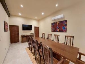a dining room with a long wooden table and chairs at Hacienda Santa Cruz Merida in Mérida