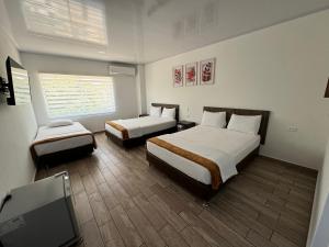 a hotel room with two beds and a flat screen tv at Hotel FENIX in Doradal