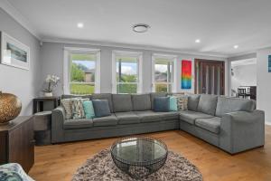 a living room with a couch and a table at Time2Reflect - the most relaxing Bowral getaway! in Bowral
