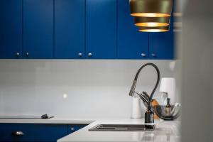 a kitchen with blue cabinets and a sink at Time2Reflect - the most relaxing Bowral getaway! in Bowral