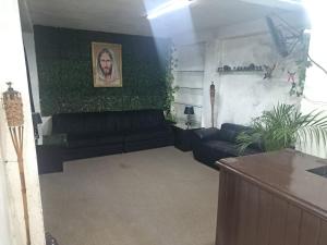 una sala de estar con un sofá negro y plantas en Hotel CASA ORTIZ, en Zorita