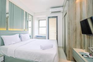 Μια τηλεόραση ή/και κέντρο ψυχαγωγίας στο Cozy Stay Studio at Transpark Cibubur Apartment By Travelio