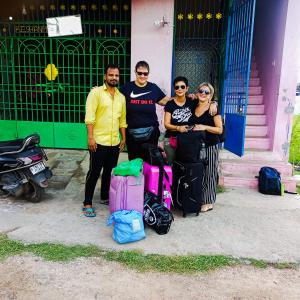 a group of people standing in front of a building with luggage at Sai Homestay in Kanchipuram