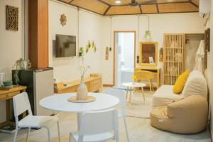 a living room with a table and a couch at Buri Gallery House in Chiang Mai +55 photos