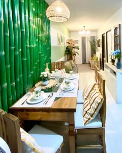 a dining room with a wooden table and a green wall at Staycation at Camella Manors Verdant Palawan in Puerto Princesa City