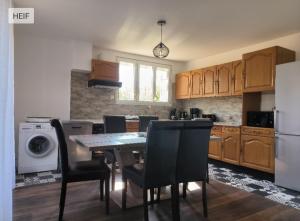 eine Küche mit Tisch und Stühlen und einem Kühlschrank in der Unterkunft Charmante maison tourangelle proche Amboise in Mosnes