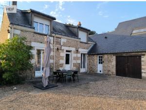 ein Haus mit einem Tisch und Stühlen davor in der Unterkunft Charmante maison tourangelle proche Amboise in Mosnes