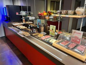 a bakery counter with pastries and other food items at Brit Hotel Confort Montauban in Montauban