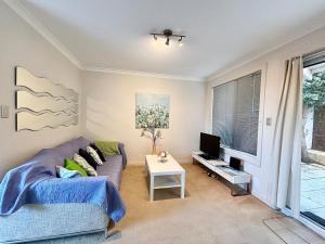 a living room with a couch and a tv at Urban Oasis Townhouse East Perth in Perth