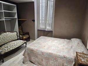 a bedroom with a bed and a chair and a window at Hôtel des Jacobines in Chalon-sur-Saône