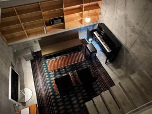 日出町SENSE Beppuwan的客厅配有钢琴,享有高空美景