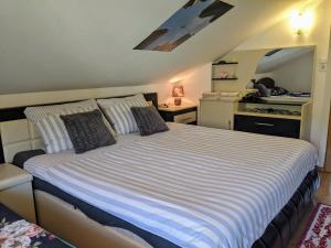 a bedroom with a large white bed with pillows at Apartmani Hrastik 2 in Bihać