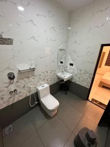 a bathroom with a toilet and a sink at Halfmoon Homestay in Kalyānpur