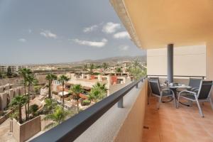 a balcony with a table and chairs looking out at the city at Apartamento Vista Paraiso in Adeje