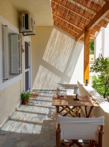 een patio met een houten tafel en 2 stoelen bij Little Summer House in Toploú