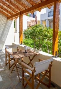 een houten tafel en stoelen op een terras bij Little Summer House in Toploú