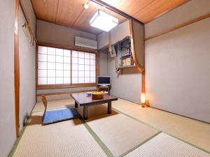 a room with a table and a tv in it at Yamamoto Ryokan in Kyoto