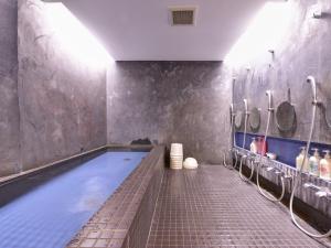 a bathroom with a swimming pool with sinks and mirrors at Yamamoto Ryokan in Kyoto