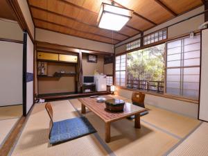 a living room with a wooden table and chairs at Yamamoto Ryokan in Kyoto