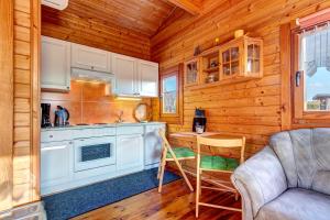 a kitchen with a couch and a table in a cabin at Grabner, Haus 2 in Ueckeritz +7 photos