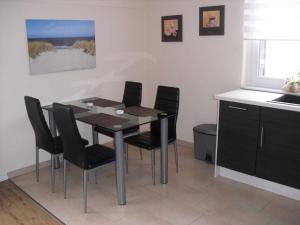 a dining room table with black chairs in a kitchen at Ferienwohnung Zwölf in Ueckeritz