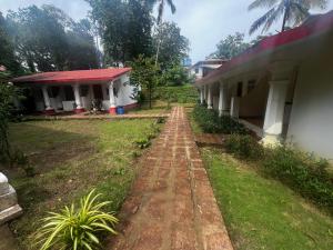 a dirt road next to a building with a yard at Maior Roma by Jolly Jolly Lester in Vagator