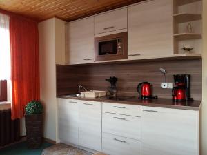 a kitchen with white cabinets and a microwave at FeWo " Anemone " in Ueckeritz