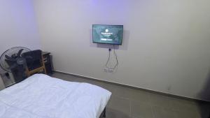 a hospital room with a bed and a tv on the wall at Nexcon Apartments in Uyo