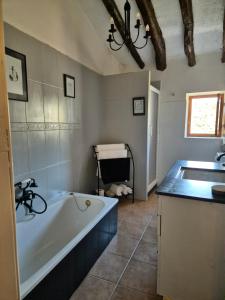 a bathroom with a bath tub and a sink at Casa rustica y tranquila en Zarra in Zarra +35 photos