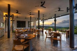 MAUA Nusa Penida Bali في نوسا بينيدا: مطعم مع طاولات وكراسي مع إطلالة