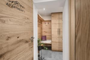 drzwi prowadzące do pokoju z drewnianymi ścianami w obiekcie Apartment NH96 inklusive kostenfreiem Eintritt in die Alpentherme w mieście Bad Hofgastein