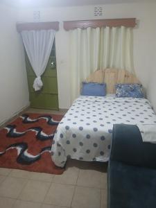 una camera da letto con un letto con un piumone blu e bianco di Studio Space a Nairobi