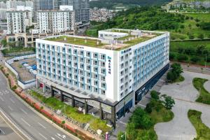 an overhead view of a large white building with a green roof at Firstcity Hotel YEOSU in Yeosu