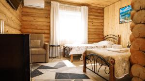 a bedroom with two beds and a chair and a window at Eco hotel & restaurant "SKALA" in Borovoye +82 photos