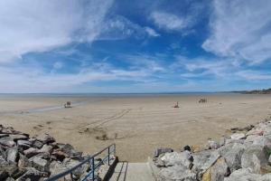 een strand met mensen die paardrijden op het zand bij Maison de vacances in Saint-Nic