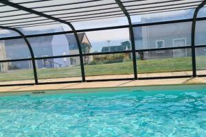 een zwembad met uitzicht op het water bij Maison de vacances in Saint-Nic