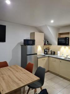 een keuken met een houten tafel en een tafel met stoelen bij Maison de vacances in Saint-Nic +9 foto's