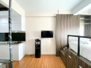 a bedroom with a bed and a television in a room at Luxury and Minimalist Studio at Patraland Urbano Apartment By Travelio in Bekasi