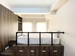 a bedroom with a bed on a wooden platform at Luxury and Minimalist Studio at Patraland Urbano Apartment By Travelio in Bekasi