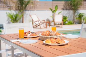 a table with two plates of food and two glasses of orange juice at Gemini Villas in Theologos