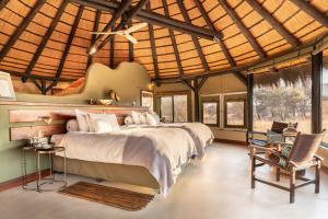 Un pat sau paturi într-o cameră la Okonjima Luxury Bush Camp