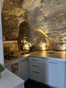 a kitchen with a sink and a stone wall at CasaCastellett in Modica