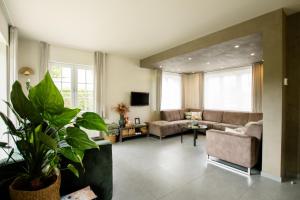 a living room with a couch and a table at Vakantievilla 3 Beaufort in Nieuwpoort