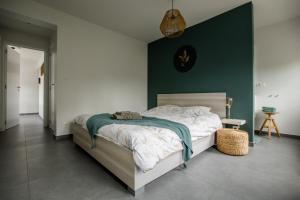 a bedroom with a bed with a green wall at Vakantievilla 3 Beaufort in Nieuwpoort
